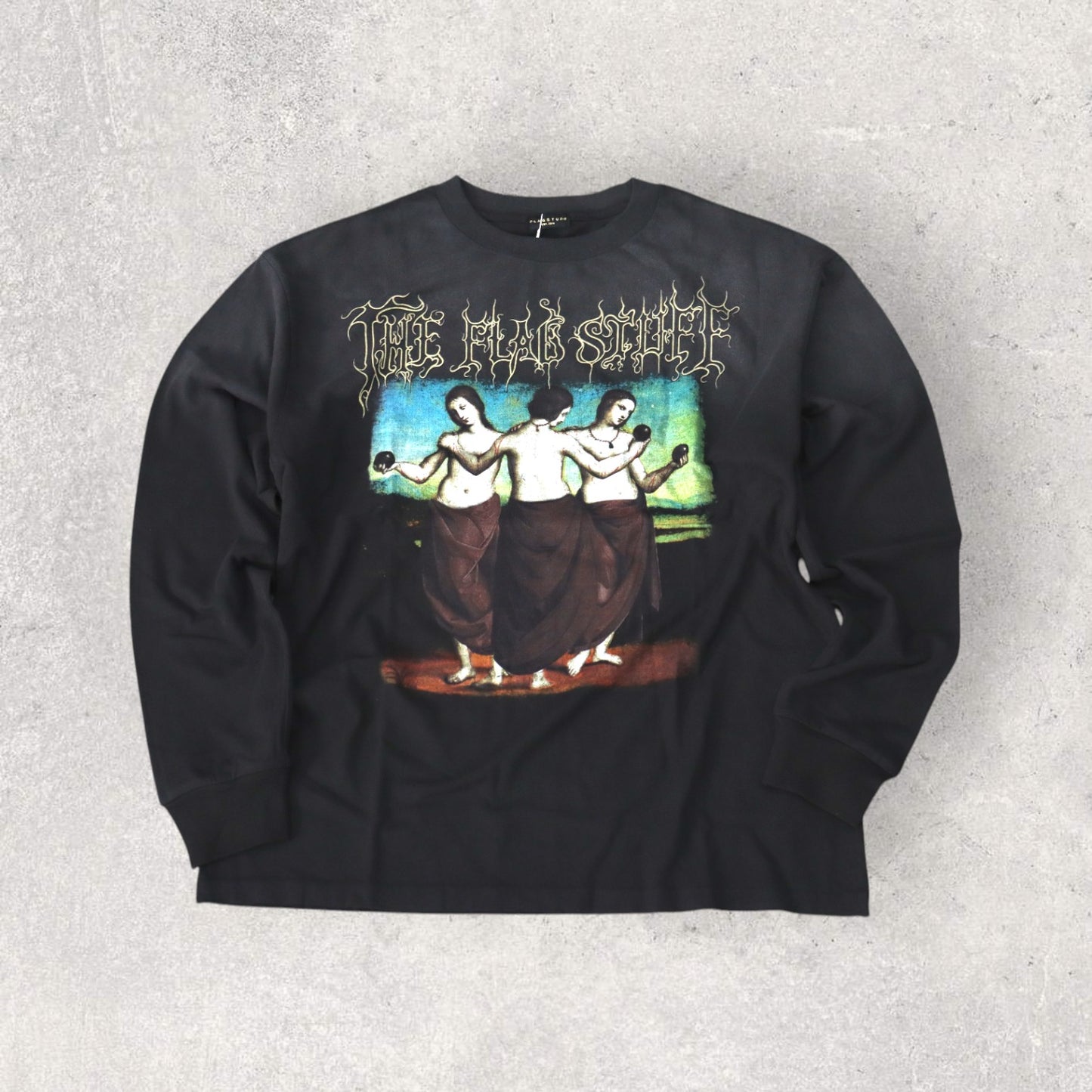 F-LAGSTUF-F(フラグスタフ)。ウォッシュ加工をされた長袖Tシャツ。中央には、ブランド名とイラストが描かれている。